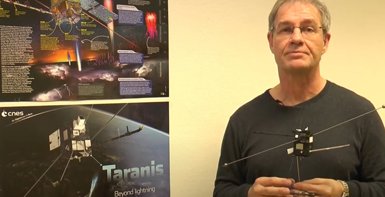 Visuel du SOT sur la mission Taranis : chercheur avec sa maquette du satellite Taranis qui va observer le dessus des orages, lieu où se produisent des phénomènes physiques pationnants