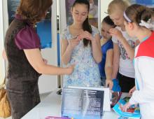 Groupe de personnes en train de sentir des flacons de l'exposition Tout est chimie